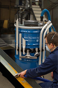 A technician uses a Heavy Duty HEPA Vac to perform scheduled maintenance on a pulverizer.